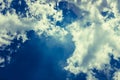Fluffy white solar clouds in the twilight light float against the dark blue sky Royalty Free Stock Photo
