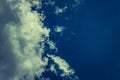 Fluffy white solar clouds in the twilight light float against the dark blue sky. Divine view. Royalty Free Stock Photo