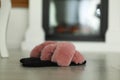 Fluffy women`s slippers on floor in room