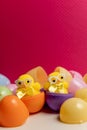 Fluffy yellow toy chicks with glasses sitting in coloured plastic easter eggs
