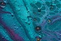 Fluid Art. Embossed mixing, craters and drips of turquoise paint. Marble effect background or texture