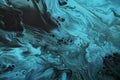 Fluid Art. Fluorescent blue waves with golden particles on black background. Marble effect background or texture