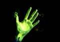 Fluorescent green hand on black background under UV light