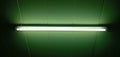 Fluorescent lamp, white, illuminated, dark green background. Royalty Free Stock Photo