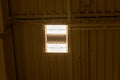 Fluorescent light fixture on corrugated metal ceiling - industrial interior - two tubes - wires and pipes.