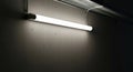 A fluorescent tube illuminates a concrete wall with dramatic shadows Royalty Free Stock Photo
