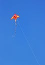 A Fluro Colored Kite against a bright blue summer sky