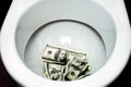 Flush money down the toilet Royalty Free Stock Photo