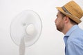 Flushed man feeling hot in front of a fan Royalty Free Stock Photo