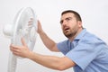 Flushed man feeling hot in front of a fan Royalty Free Stock Photo