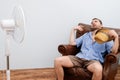 Flushed man feeling hot in front of a fan Royalty Free Stock Photo