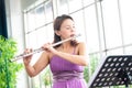 Flute classical instrument profestional player playing song. A young and elegant Asian woman plays the flute