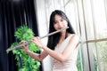 Flute classical instrument profestional player playing song. A young and elegant Asian woman plays the flute