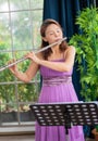 Flute classical instrument profestional player playing song. A young and elegant Asian woman plays the flute