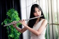 Flute classical instrument profestional player playing song. A young and elegant Asian woman plays the flute. Vintage Stye