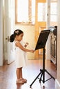 Flute, girl and child playing in home for learning, education and reading music sheet to practice performance. Art Royalty Free Stock Photo