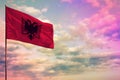 Fluttering Albania flag mockup with the space for your content on colorful cloudy sky background