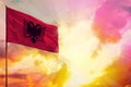 Fluttering Albania flag in top left corner mockup with the space for your text on beautiful colorful sunset or sunrise background