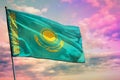 Fluttering Kazakhstan flag on colorful cloudy sky background. Prosperity concept