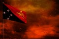 Fluttering Papua New Guinea flag mockup with blank space for your text on crimson red sky with smoke pillars background. Troubles