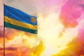 Fluttering Rwanda flag in top left corner mockup with the space for your text on beautiful colorful sunset or sunrise background