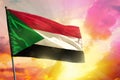 Fluttering Sudan flag on beautiful colorful sunset or sunrise background. Success concept