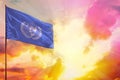 Fluttering United Nations flag in top left corner mockup with the space for your text on beautiful colorful sunset or sunrise