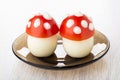 Fly-agaric - imitation from eggs with tomato and mayonnaise in saucer on wooden table