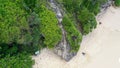 Fly by along the ridge with a pathway down to Kelingking Beach next to huge steep cliff, Nusa Penida, Bali, Indonesia