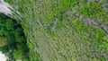 Fly by along the ridge with a pathway down to Kelingking Beach next to huge steep cliff, Nusa Penida, Bali, Indonesia