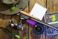 Fly box with flies and a hat on a wooden table. Royalty Free Stock Photo