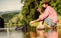 Fly fish hobby. Summer activity. successful fisherman in lake water. hipster fishing with spoon-bait. big game fishing Royalty Free Stock Photo