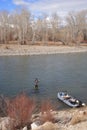 Fly fisherman casting on large river