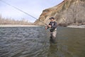Fly fisherman casting for trout on a river