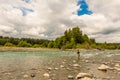 A fly fisherman fishing the fast flowing, green glacial Kitimat River, in North West British Columbia Royalty Free Stock Photo