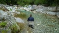 A fly fisherman fishing a small alpine stream that flows into the Soca River Royalty Free Stock Photo