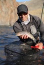 Fly fisherman holding a cutthroat trout Royalty Free Stock Photo