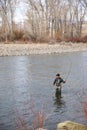 Fly fisherman hooking into a trout on river Royalty Free Stock Photo