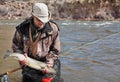 Fly fisherman with large bull trout and net