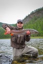 A fisherman holding a taimen trout caught on a river in Mongolia, Moron, Mongolia Royalty Free Stock Photo