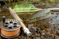 A fly fisherman's freshly caught rainbow trout, stones of a mountain river, a fishing rod and landing net. Royalty Free Stock Photo