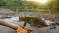 A fly fisherman's freshly caught rainbow trout, stones of a mountain river, a fishing rod and sunset. Royalty Free Stock Photo