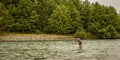 A fly fisherman spey casting while wading in a fast flowing, green, glacial river Royalty Free Stock Photo