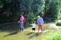 Fly fisherman using fly fishing rod in river. Grandpa and grandson are fly fishing on river. Great-grandfather and great Royalty Free Stock Photo