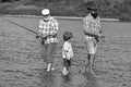 Fly fisherman using fly fishing rod in river. Family generation and people concept. Grandson with father and grandfather Royalty Free Stock Photo