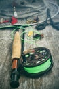 Fly fishing reel with old hat on bench Royalty Free Stock Photo