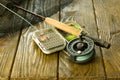 Fly fishing rod , box of flies and a landing net on the old wooden table. All ready for fishing. Royalty Free Stock Photo