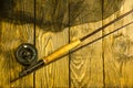 Fly fishing rod ,flie and a landing net on the old wooden table. All ready for fishing. Royalty Free Stock Photo