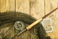 Fly fishing rod ,flie and a landing net on the old wooden table. All ready for fishing. Royalty Free Stock Photo