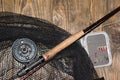 Fly fishing rod ,flie and a landing net on the old wooden table. All ready for fishing. Royalty Free Stock Photo